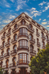A beautifully designed historical building that showcases intricate balconies against a vibrant, colorful sky in Tarragona, Spain