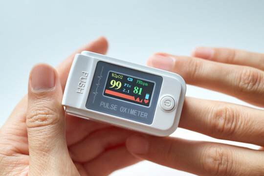 Accurate measurement of vital signs. Anonymous female using medical professional digital pulse oximeter to check oxygen level and heart rate through her fingertip