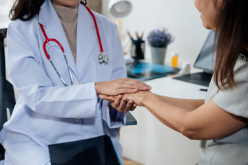 Obraz premium Doctor hands is touching the old lady in retired life patient's hand for support and cheerful when treatment and heal illness.