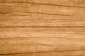 A close-up shot of a light brown wooden surface with visible grain and cracks.