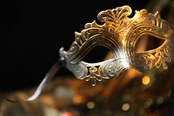 Beautiful golden carnival mask in darkness, closeup