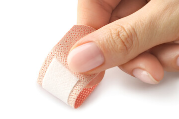 Woman putting medical adhesive bandage on white background, closeup