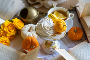 Cup of tea with orange and small pumpkins on white table, September.