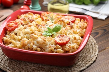 Delicious al forno pasta in baking dish on wooden table, closeup