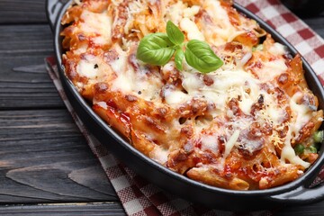 Delicious al forno pasta in baking dish on wooden table, closeup