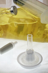 Male silicone catheter against the background of a bag with yellow liquid