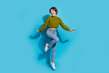 Fototapeta premium Full length photo of glad satisfied girl wear trendy clothes look down empty space banner news isolated on cyan color background