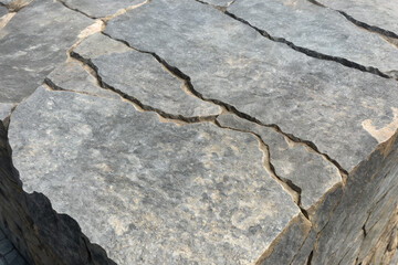 Obraz premium stone wall texture with cracks running through it, baking in the summer sun