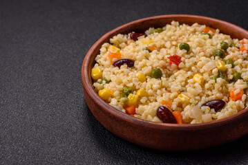 Boiled wheat bulgur porridge with vegetables peppers, peas, corn