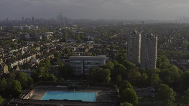 Aerial view of Herne Hill neighborhood featuring brutalist tower block Hurst Street Estate and Meath Estate behind Brockwell Park Lido outdoor swimming pool during on Dulwich Road in Herne Hill