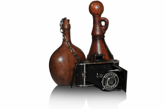 Old vintage camera on the background of two vintage old bottles isolated on white background - Powered by Adobe