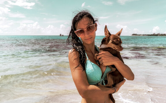 Pretty woman with dog on beach Playa del Carmen Mexico.