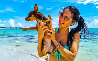 Pretty woman with dog on beach Playa del Carmen Mexico.