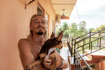 Happy man with dog on his arm in Playa del Carmen Mexico.