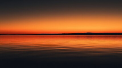 Fototapeta premium The horizon glows with vibrant orange and blue shades as dusk settles over peaceful waters, creating a tranquil atmosphere and a sense of serenity