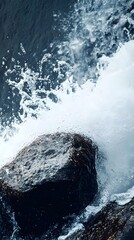 A close-up of water splashing against smooth stones at the base of a waterfall, showcasing the dynamic energy of nature