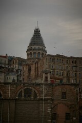 Obraz premium View of Galata Tower in Istanbul, Turkey, with surrounding historic buildings and a cloudy sky