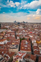 Obraz premium Aerial view of Madrid cityscape with red-tiled rooftops and skyscrapers.