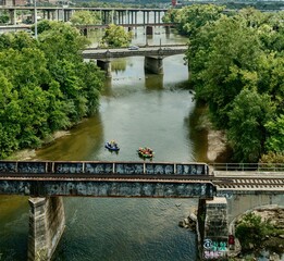 Aerial view of river rafting under urban bridges