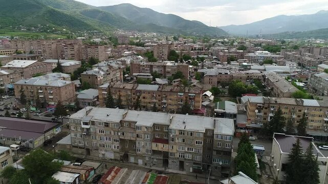 Drone above Vanadzor buildings in Armenia at the daytime, showing mountains in the background