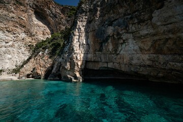 Serene, turquoise waters reflecting coastal cliffs on a sunny day in Zakynthos Island, Greece