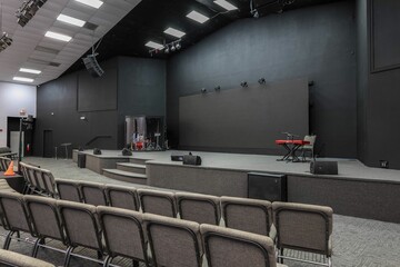 Empty modern auditorium with stage and musical instruments