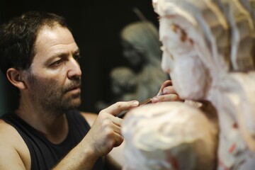 Male sculptor working on a detailed sculpture