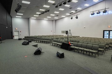 Empty auditorium with gray chairs and stage setup