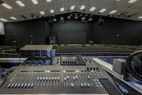 Empty auditorium with sound mixing console and stage