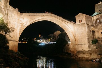 Stari Most bridge in Mostar, Bosnia and Herzegovina, with illuminated buildings in the background