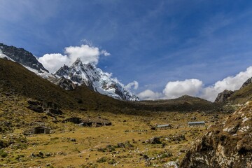Stunning view of the snow-capped Salkantay Mountain peak with clouds against a clear blue sky.