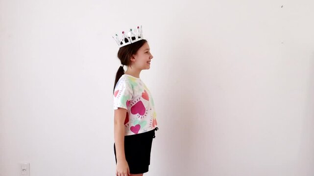 Menina pr&eacute; adolescente sorridente usa coroa de princesa 