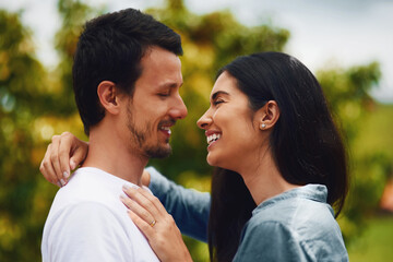 Fototapeta premium Love, hug and smile with couple in park for romance, bonding and summer vacation. Happiness, commitment and care with man and woman relax on date in nature for marriage, support and partnership
