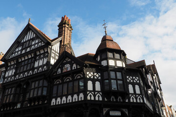 Old half timbered buildings on the corner of Eastgate and bridge street with stairs leading to the upper rows in Chester