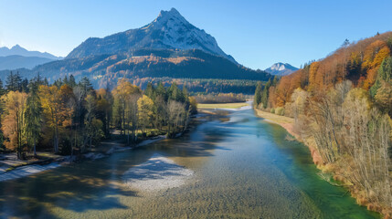 Naklejka premium Aerial view of the Salza River with a mountain peak in the background on a fall day, surrounded by forest in Wildalpen, Austria.