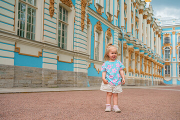 Little girl child walks to Catherine's Park with a palace, family tourism, active childhood.