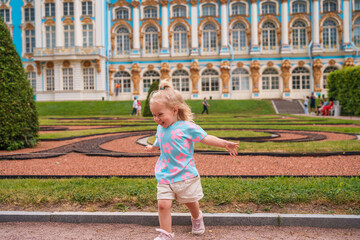 Little girl child walks to Catherine's Park with a palace, family tourism, active childhood.