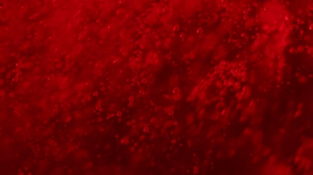 Red bubbles slowly rise up, red dark liquid