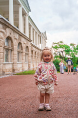 Little girl child walks to Catherine's Park with a palace, family tourism, active childhood.