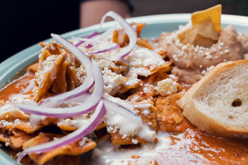 Platillo Mexicano chilaquiles con carne de puerco acompañado de frijoles y pan