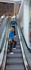 People standing on an escalator and travelling upwards 