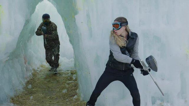 Female paintballer hitting man as he comes out of ice tunnel - slow motion stunt