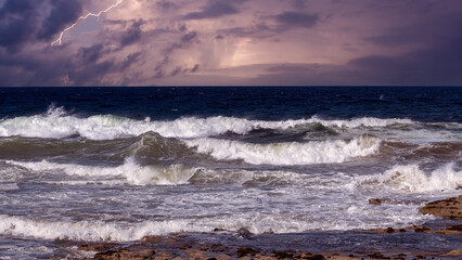 A turbulent sea churns under a stormy sky, illuminated by jagged lightning bolts.