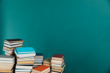 Piles of books for education in university library on green background