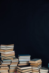 lots of stacks of old vintage books to study in the library on a black background