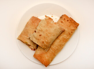 Meat shawarma on a white plate. Burritos with meat.