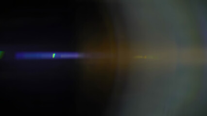 Cinematic anamorphic lens flares with vivid light streaks and reflections against a black...
