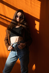 Beautiful fashionable slim woman wearing glasses, jeans and jacket