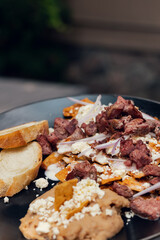 Platillo Mexicano chilaquiles con carne de puerco acompañado de frijoles y pan