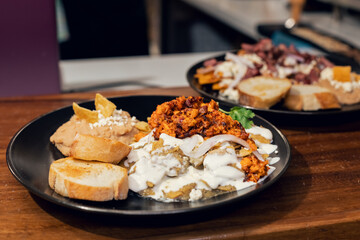 Platillo Mexicano chilaquiles con carne de puerco acompañado de frijoles y pan